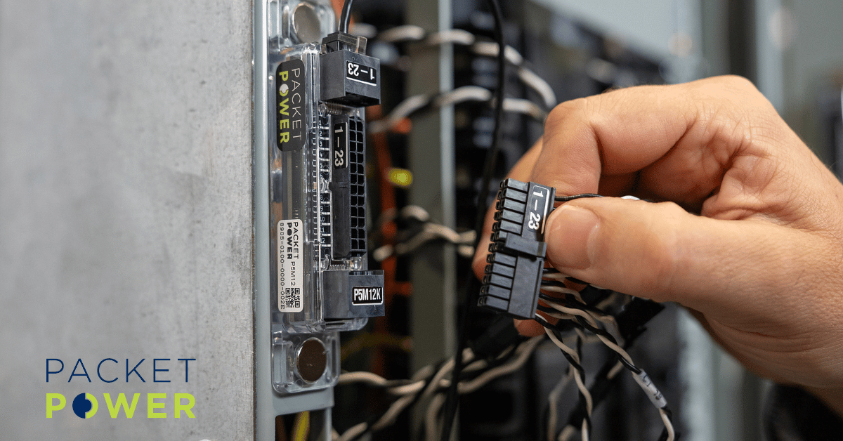 Packet Power branch circuit monitor being connected to a cable harness in a densely wired electrical panel for granular data center power monitoring